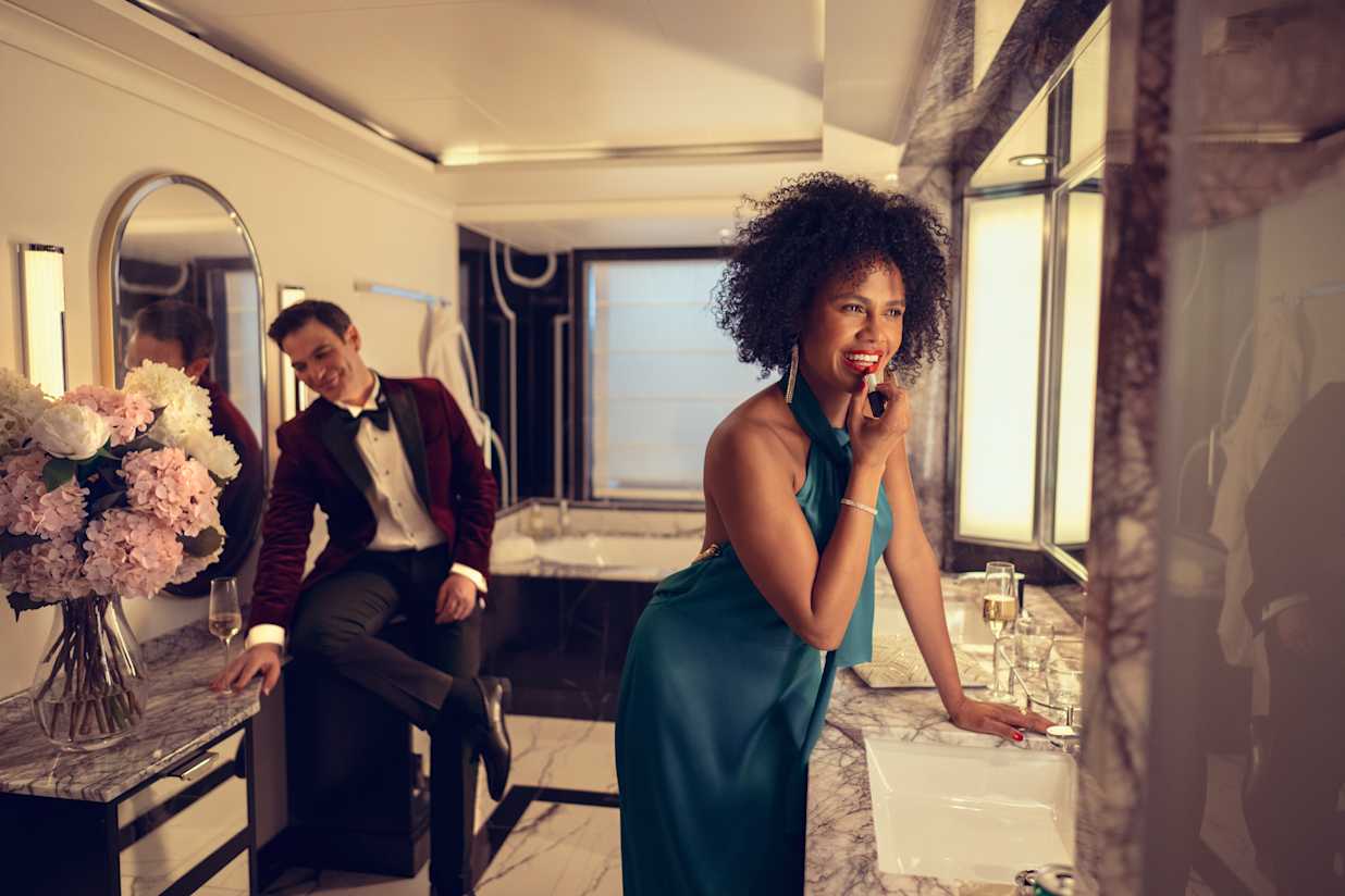 A couple getting ready for the evening in A Grills Suite bathroom on a cunard cruise ship